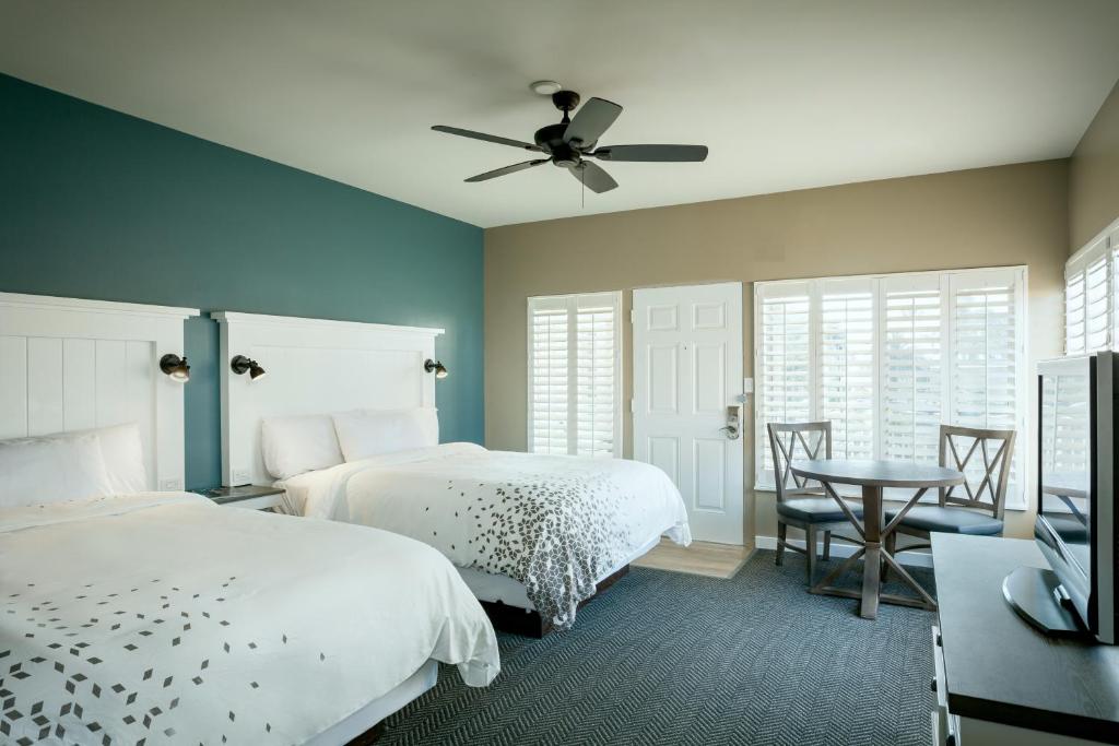 um quarto com 2 camas e uma ventoinha de tecto em Pacific Shores Inn em San Diego