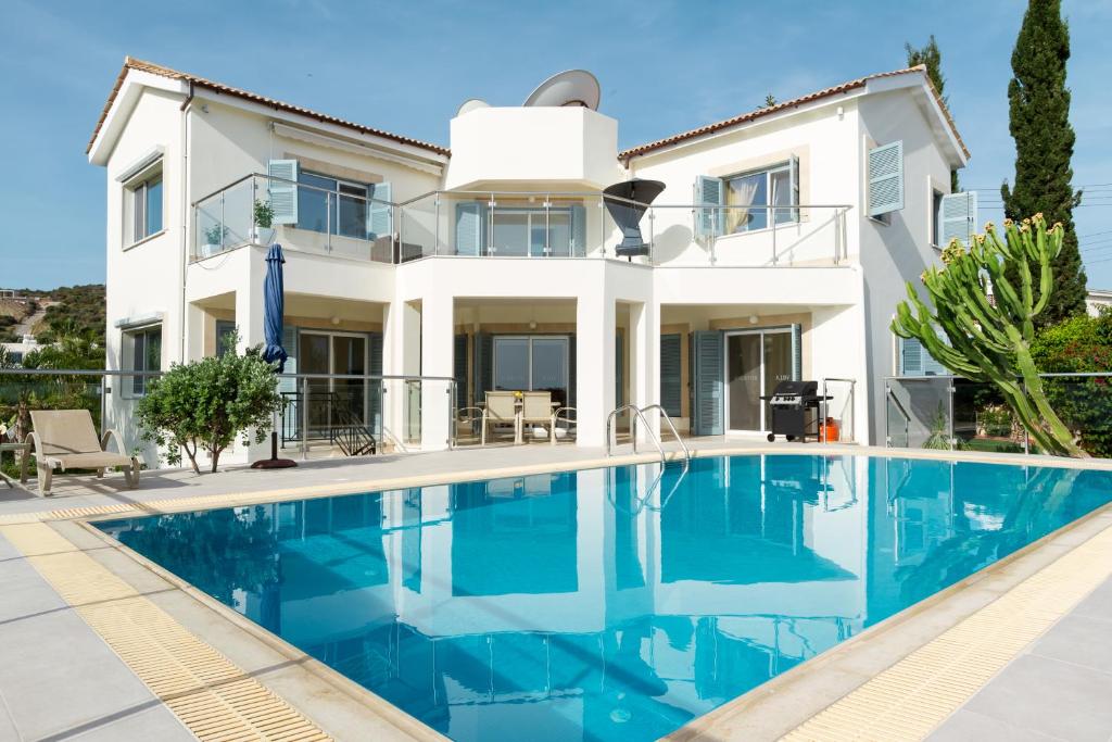 a villa with a swimming pool in front of a house at Villa Riverside in Polis Chrysochous