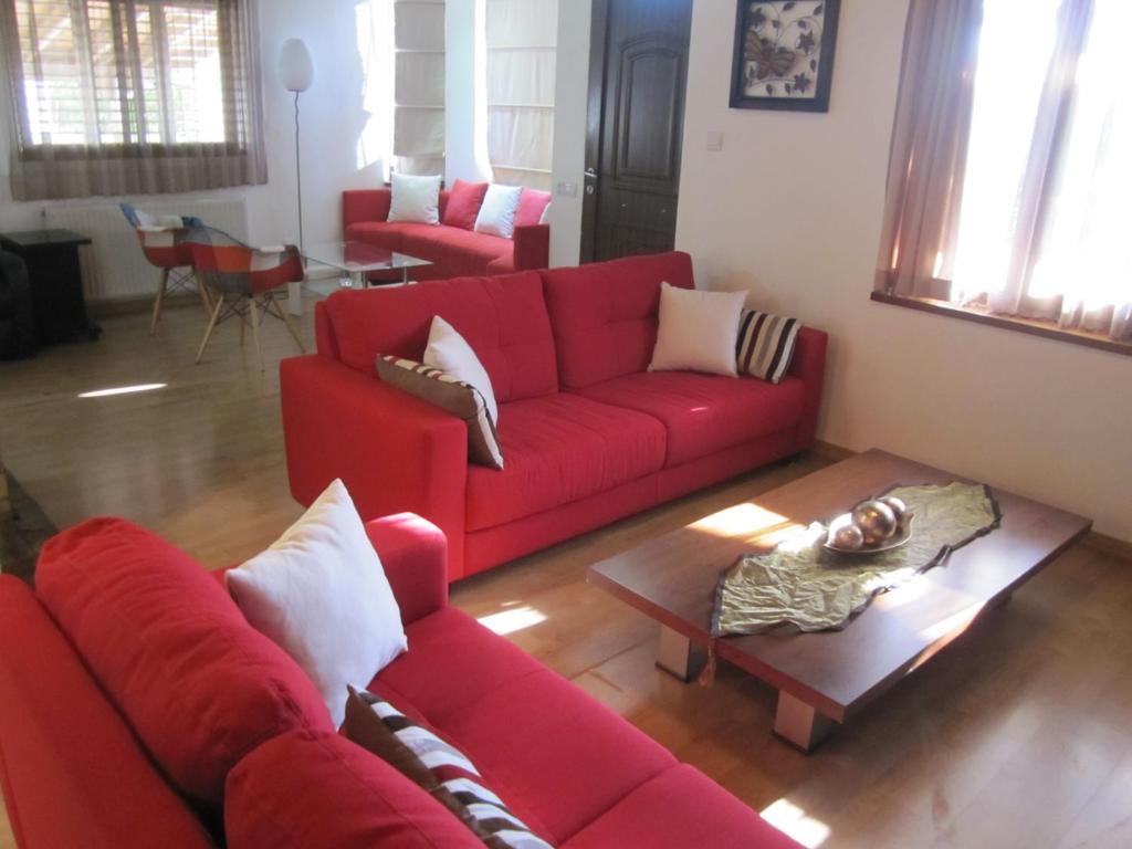 a living room with a red couch and a table at Jasmine Residence in Nicosia