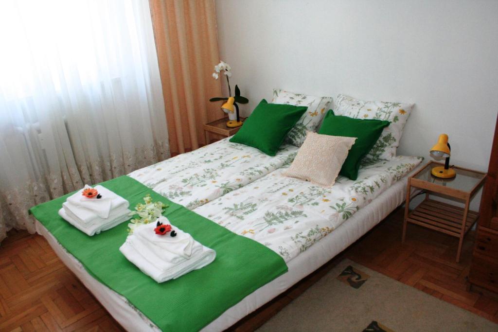 a bedroom with a bed with green and white sheets at Seven Heaven Warsaw/Siódme Niebo Warszawa in Warsaw