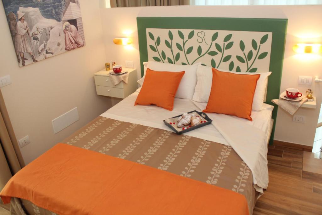 a small bedroom with a bed with orange pillows at Summa Resort in Roccasecca