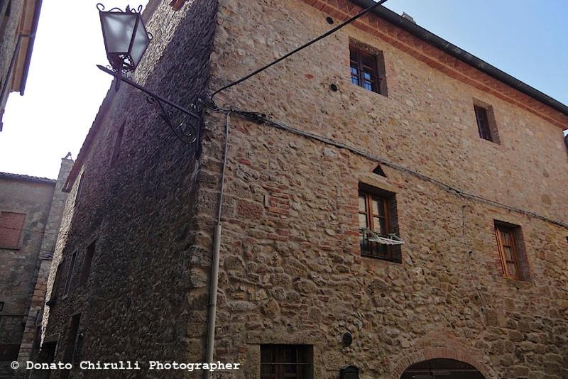 un edificio de ladrillo con una luz de la calle al lado en Centro Storico, en Casale Marittimo