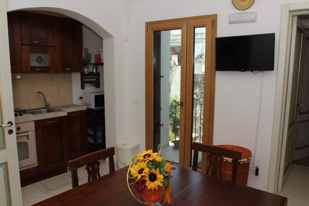 uma cozinha com uma mesa com um vaso de flores em Ciddini em Andrano