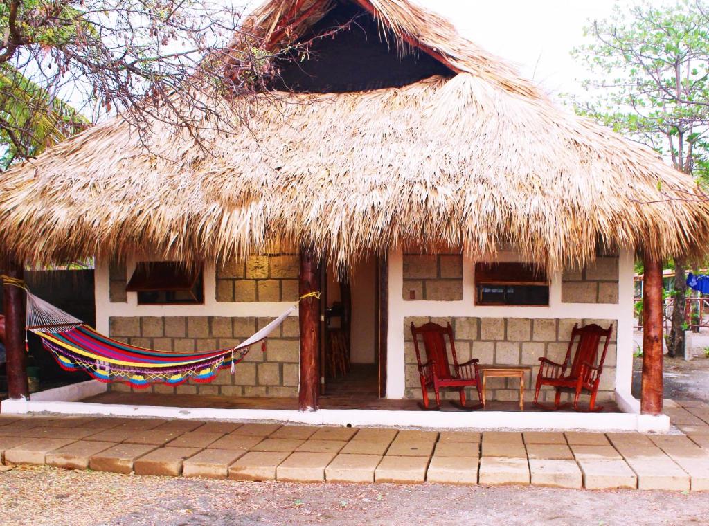 a hut with two chairs and a hammock in front of it at La Casita Nica in San Diego