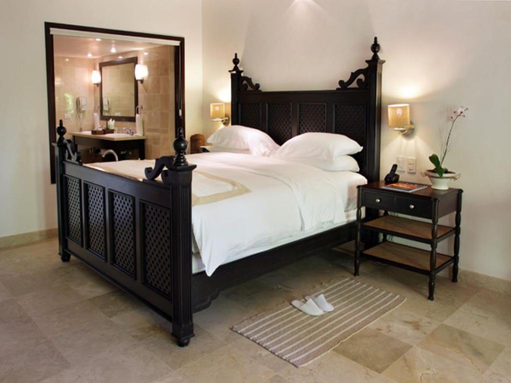 a bedroom with a large bed with a large mirror at Casa Colonial Beach & Spa in San Felipe de Puerto Plata