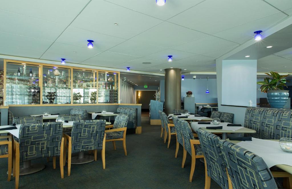 a restaurant with tables and chairs and a bar at Avista Resort in Myrtle Beach