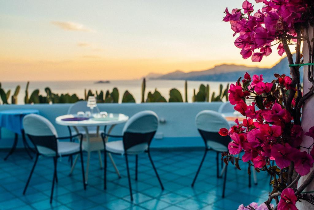 普萊伊亞諾的住宿－里費歐雷雷酒店，鲜花盛开的庭院里的桌椅
