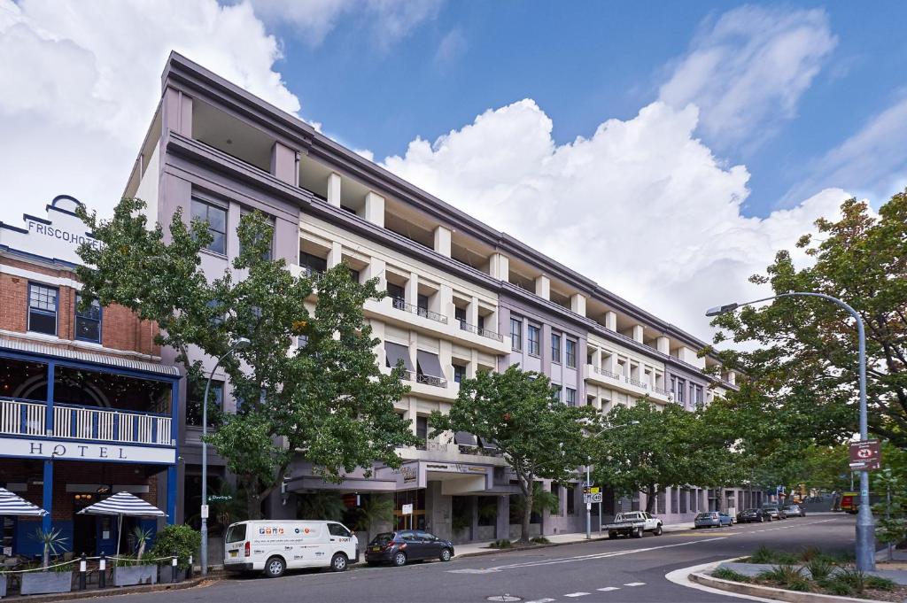 a building on a street with cars parked on the street at Nesuto Woolloomooloo in Sydney