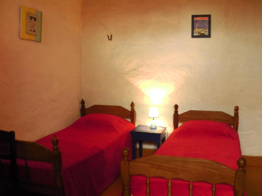 2 Betten in einem Zimmer mit roter Bettwäsche in der Unterkunft Panambi in Asunción
