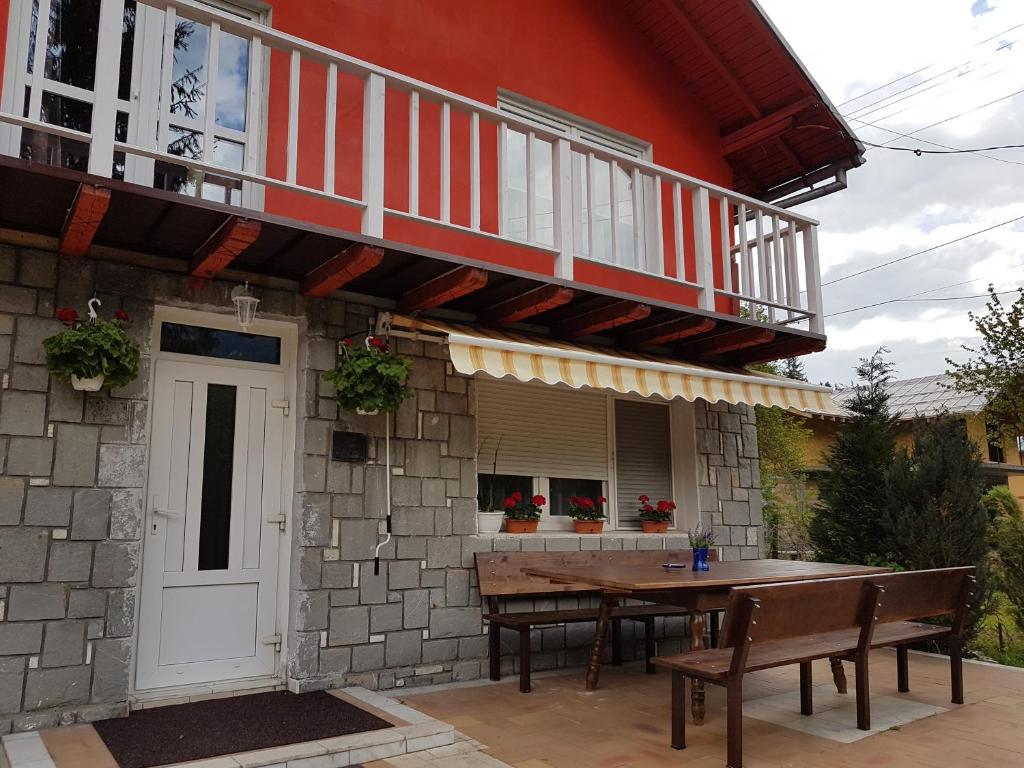 a house with a table and a balcony at Vila Gabriela in Buşteni