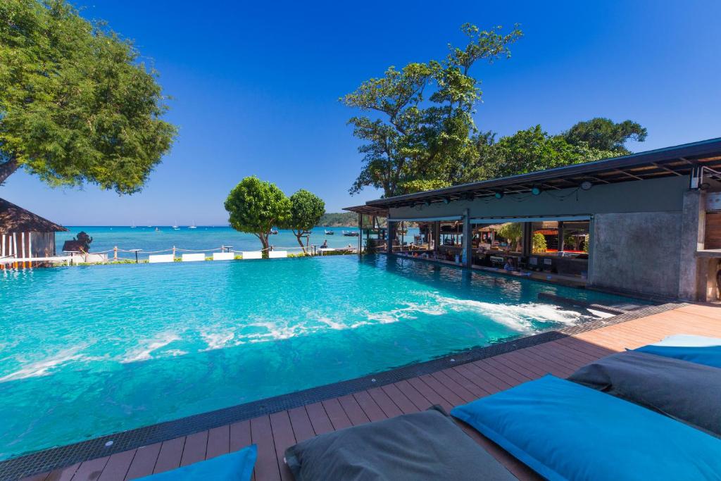 an infinity pool at a resort with the ocean in the background at Ibiza Phi Phi in Phi Phi Don