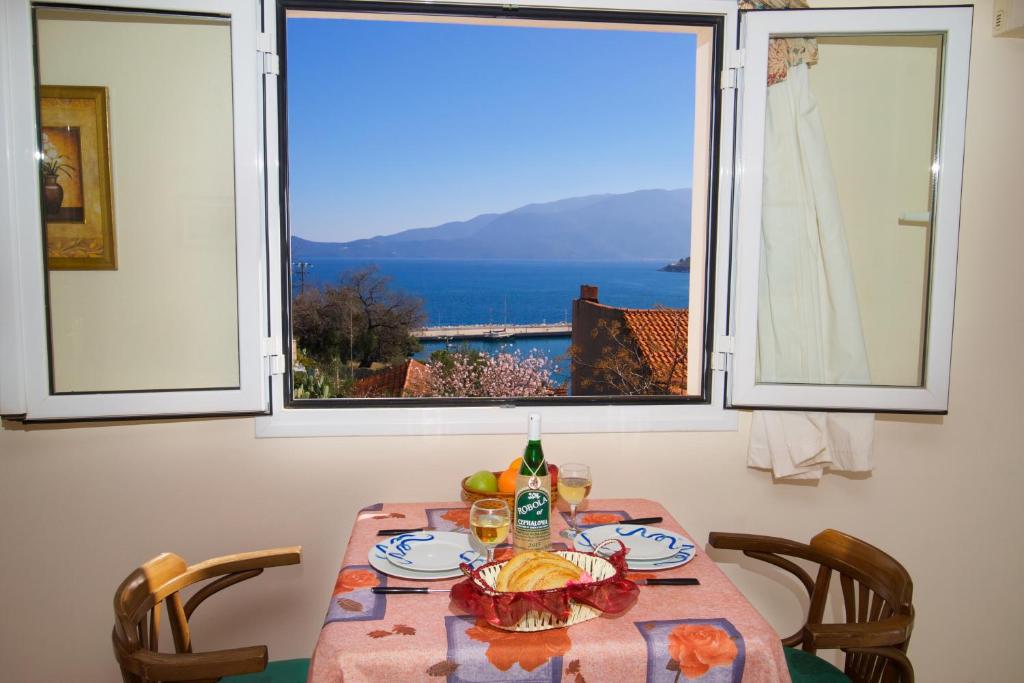 een tafel met uitzicht op de oceaan vanuit een raam bij Boulevard Aetos Suites in Ayia Evfimia