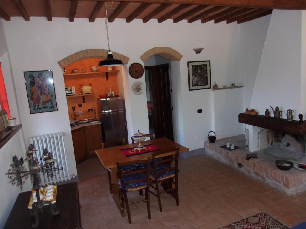 a kitchen and dining room with a table and a fireplace at Podere Sammonti in Monteriggioni