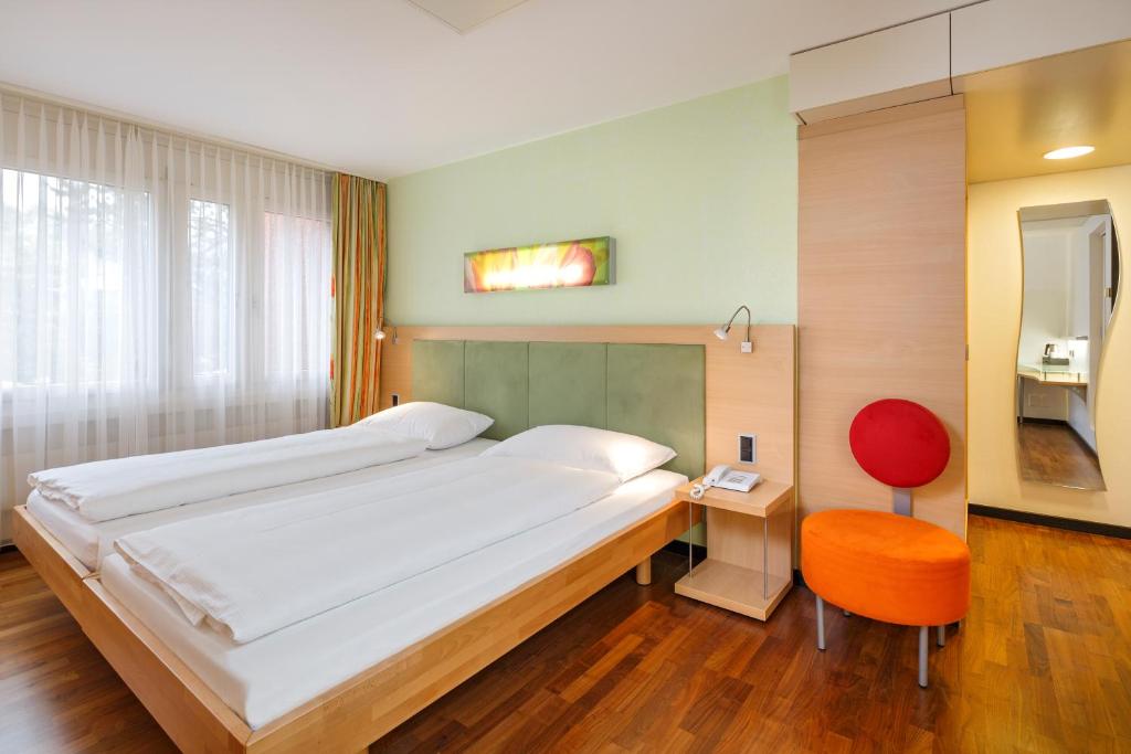Postel nebo postele na pokoji v ubytování Ramada by Wyndham Baden Hotel du Parc