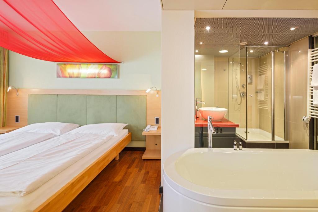 Postel nebo postele na pokoji v ubytování Ramada by Wyndham Baden Hotel du Parc