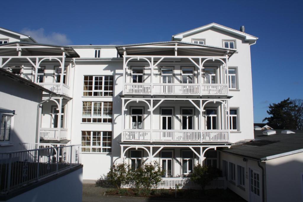 - un bâtiment blanc avec des balcons sur le côté dans l'établissement Ferienwohnung im Ostseebad Göhren in Strandnähe, Kurhaus Nordstrand,Nähe Binz und Sellin, à Göhren