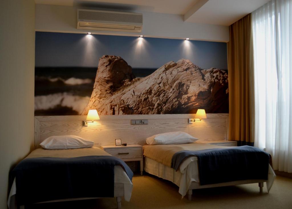 ein Hotelzimmer mit 2 Betten und einem Gemälde an der Wand in der Unterkunft Hotel Morski in Gdynia