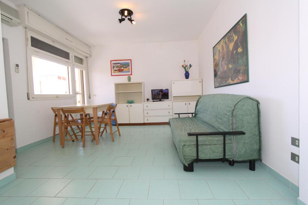 a living room with a chair and a table at Conchiglia apartments in Lido di Pomposa