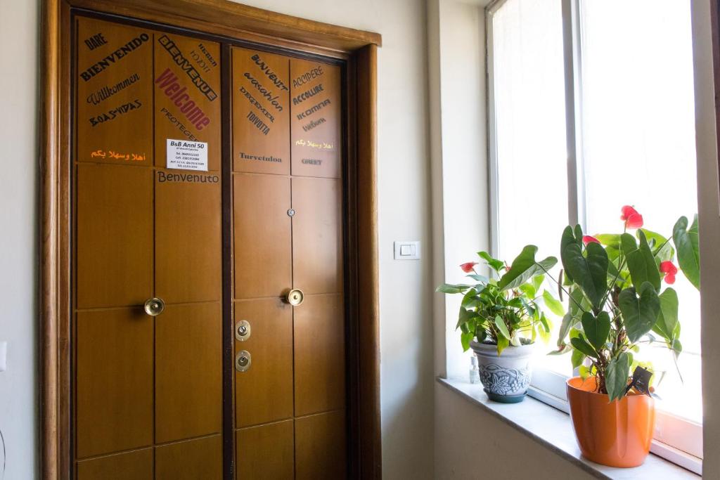 a row of lockers in a room with plants on a window at B&B Anni 50 in Rome