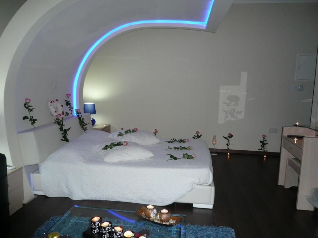 a bedroom with a white bed with a blue light at Esperando in Maroni
