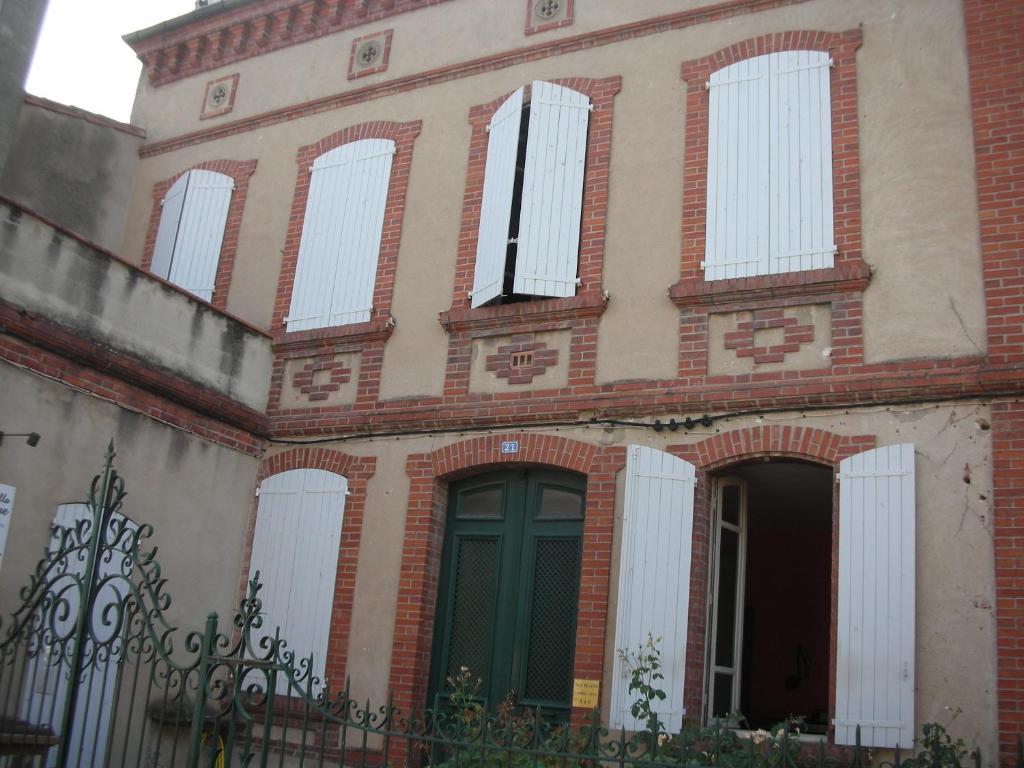 アルビにあるChambres d'Hôtes Villa Bellevueの緑のドアと窓のある古いレンガ造りの建物