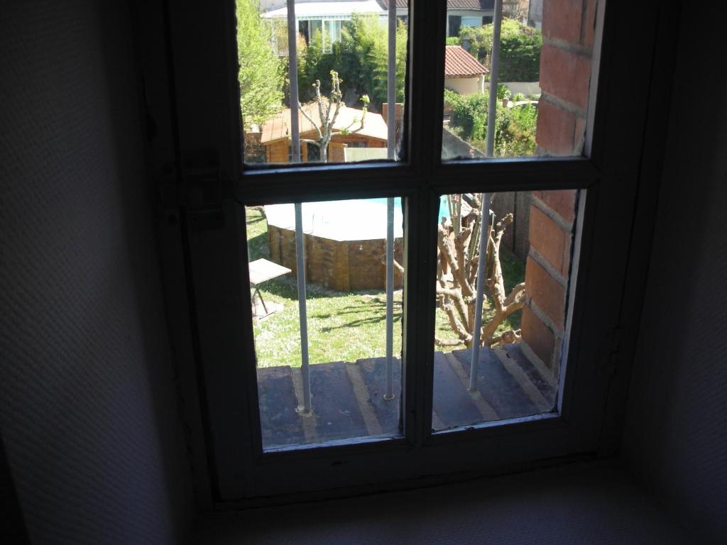 an open window with a view of a yard at Chambres d&#39;Hôtes Villa Bellevue in Albi