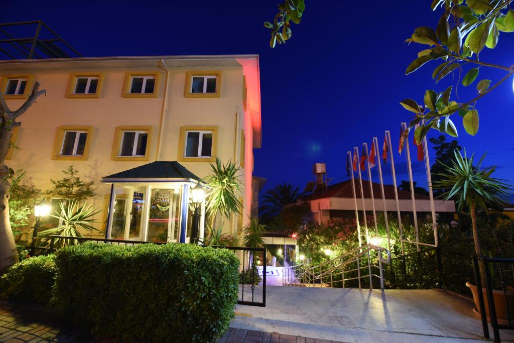 un edificio con bandiere di fronte ad esso di notte di Muz Hotel a Alanya