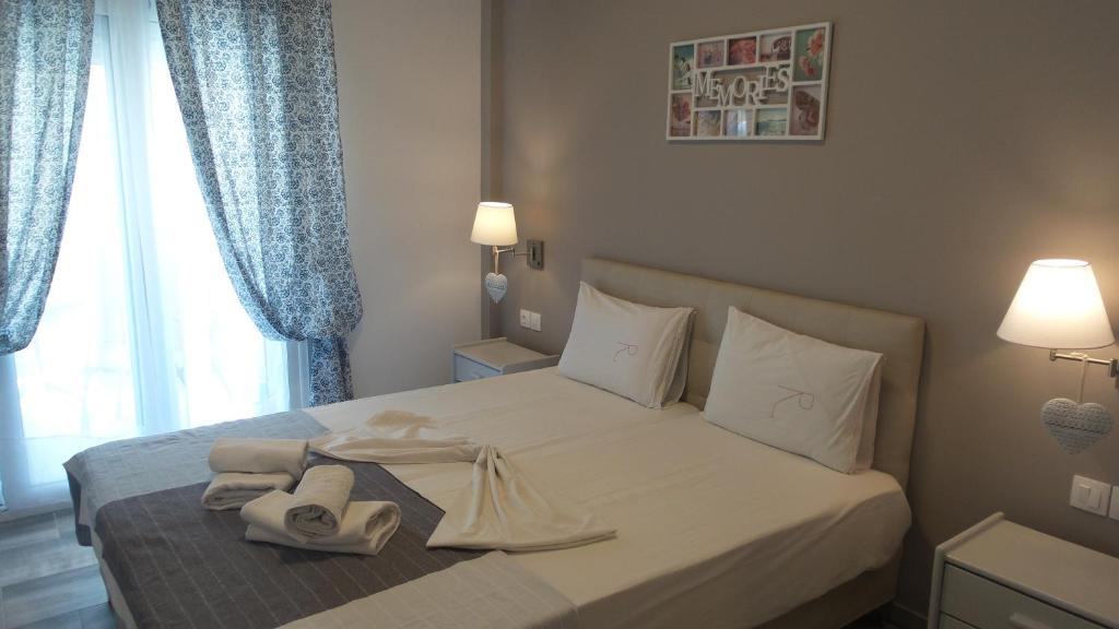 a bedroom with a white bed with towels on it at House Roula in Neos Marmaras