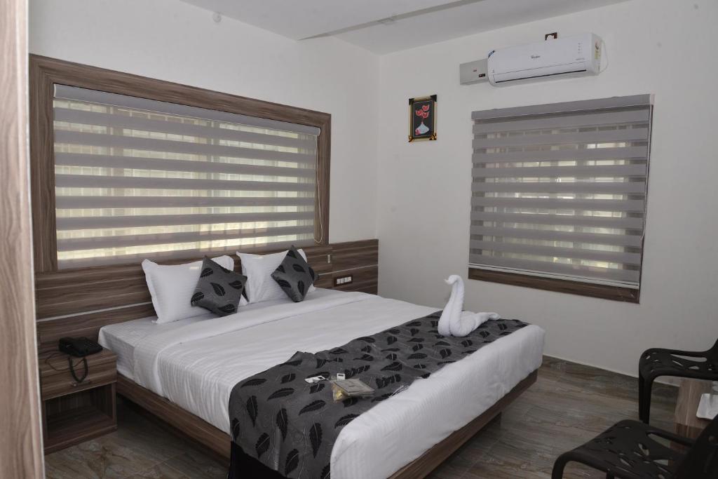 a bedroom with a bed with black and white pillows at Suroor Tourist Home in Virajpet