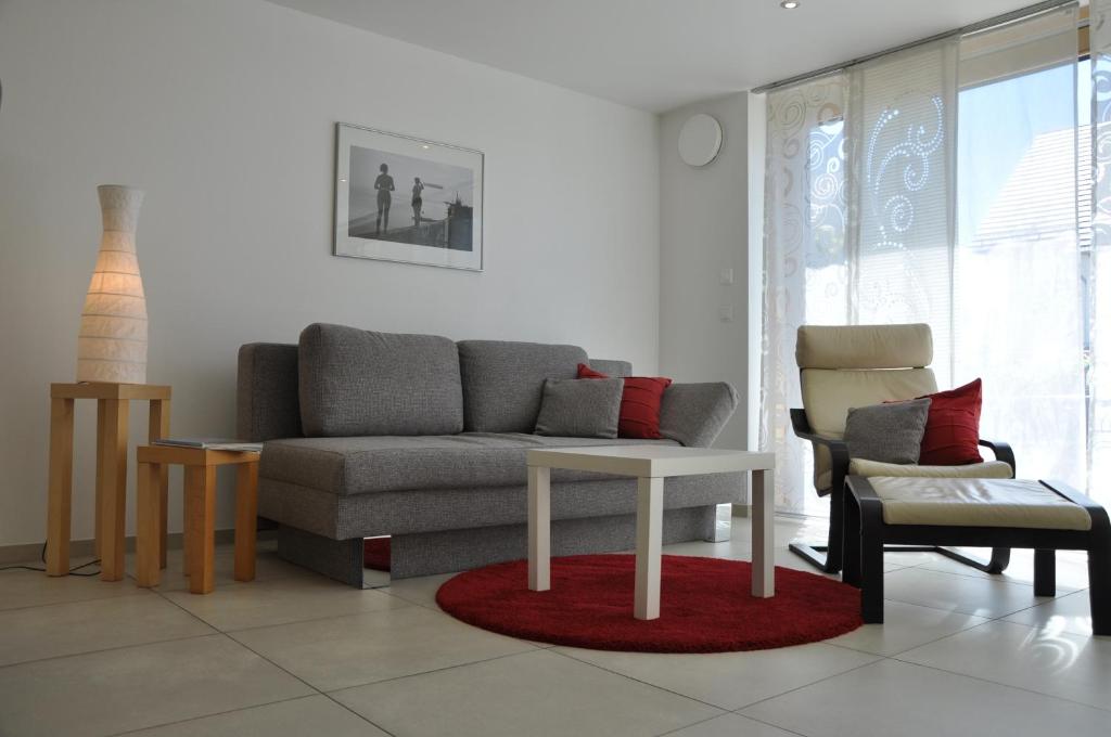 una sala de estar con un sofá y una mesa en Ferienwohnung Fischbach, en Friedrichshafen