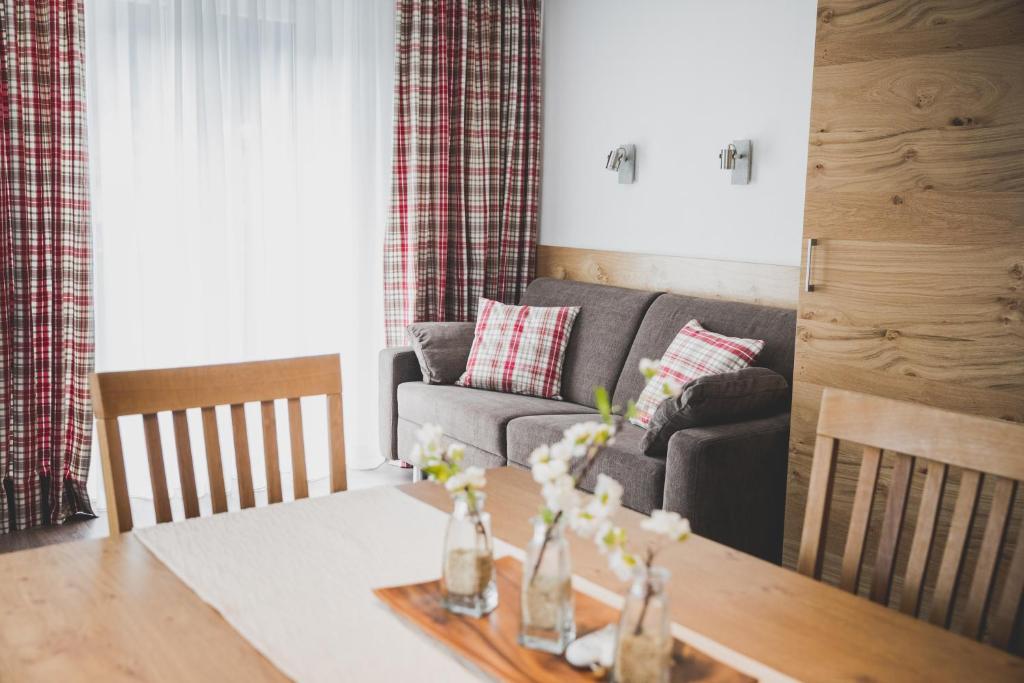 a living room with a table and a couch at Hotel Montfort in Sankt Anton am Arlberg