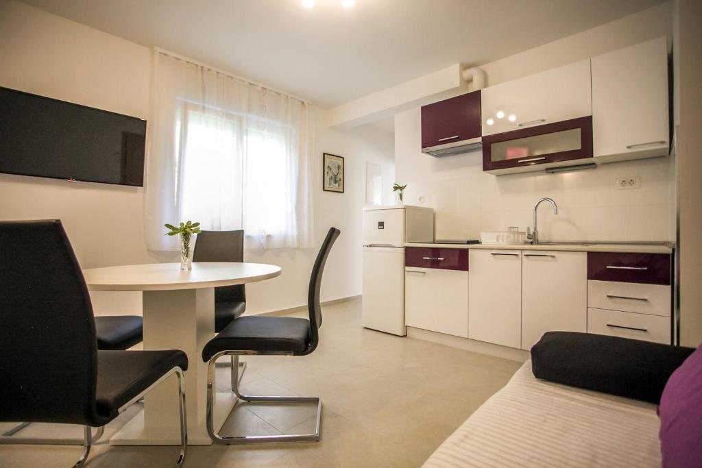 a small apartment with a table and a kitchen at Apartments Lovor in Split