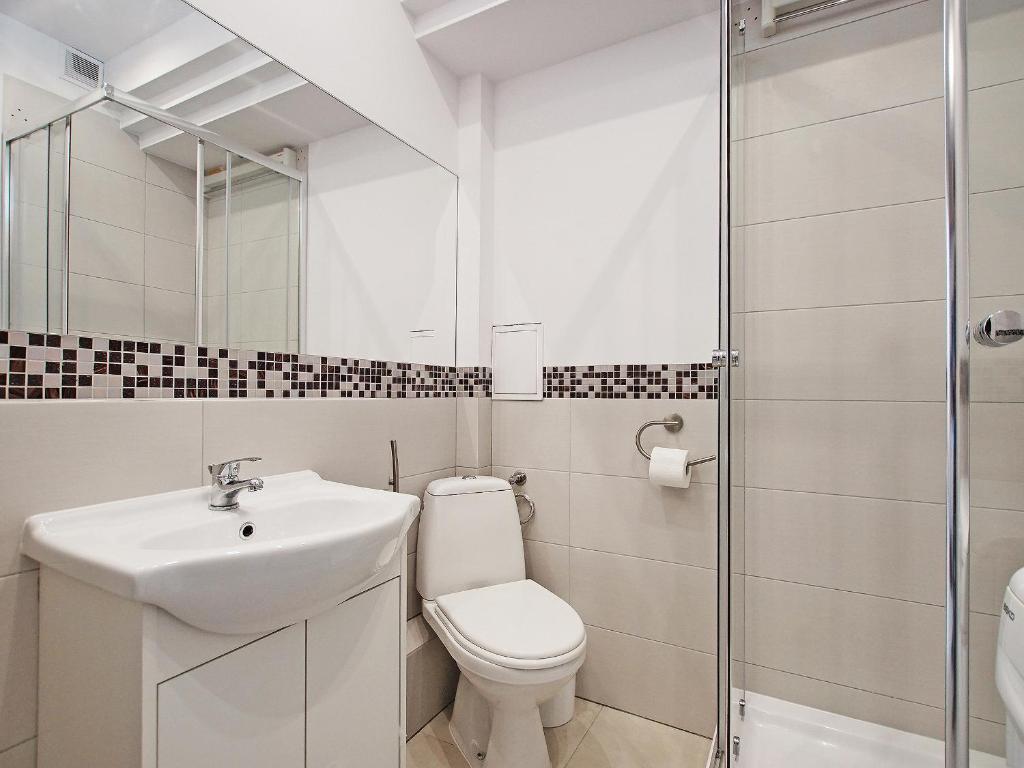 a bathroom with a toilet and a sink and a shower at Apartament Starogdański 4 in Gdańsk