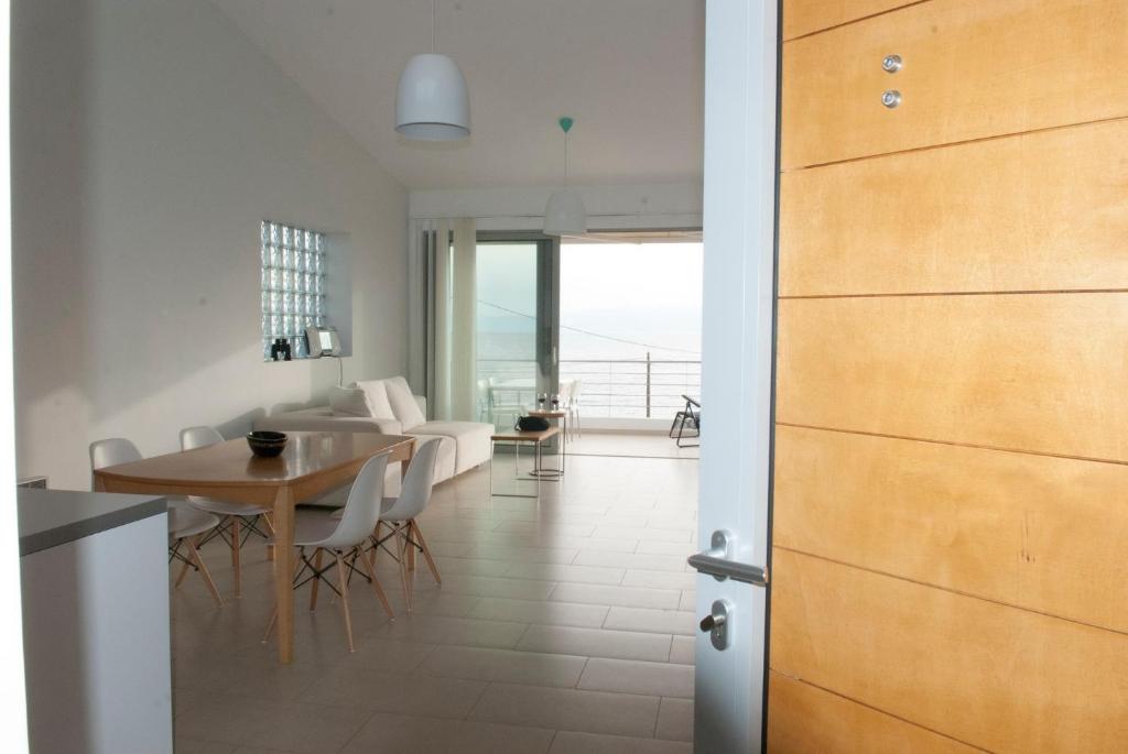 a kitchen and dining room with a table and a door at ILIOS H&E house in Elia Laconias