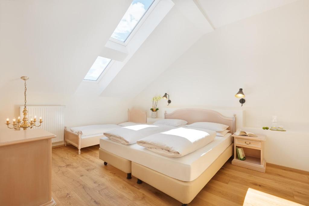 a white bedroom with two beds and a skylight at Historic Hotel Bircher B&B Apartments near Sterzing in Campo di Trens