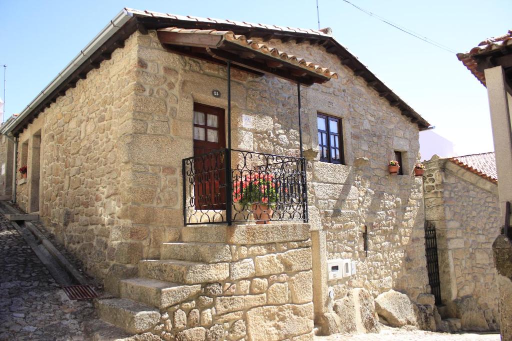 a stone building with a balcony and a door at Casa do Balcao in Castelo Novo
