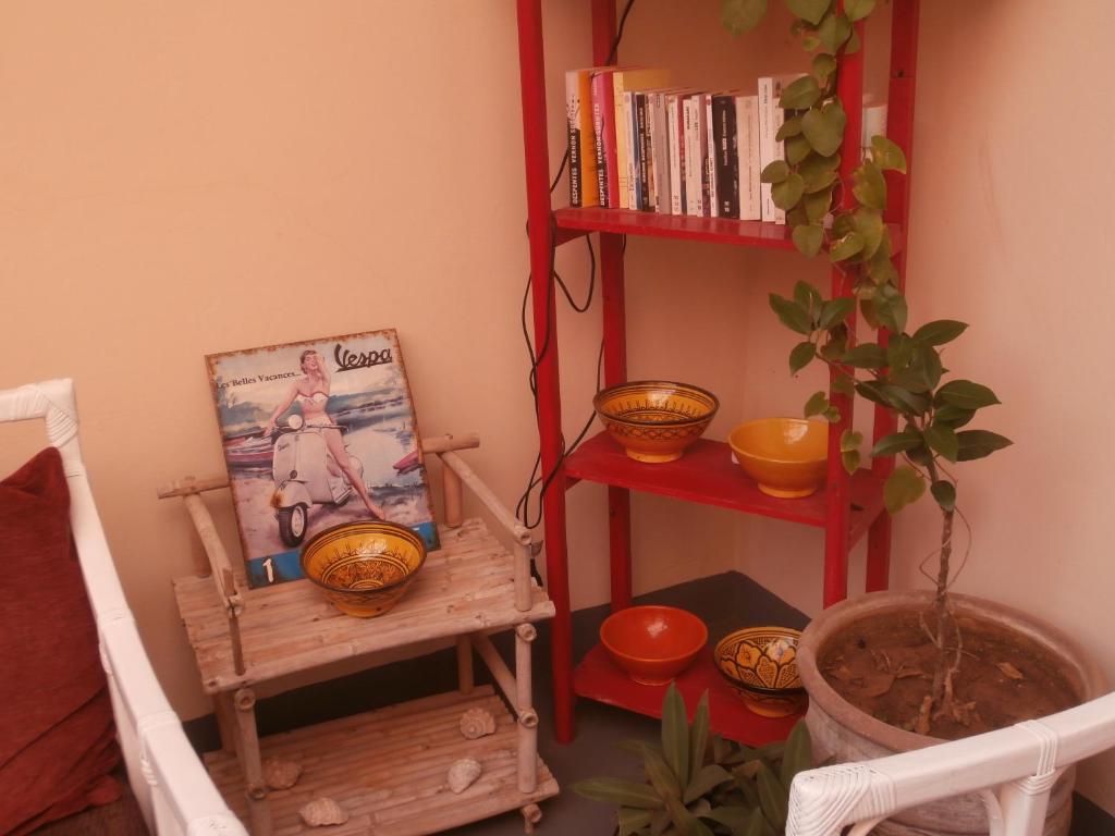a room with a book shelf and a wooden chair at Maison Xanadu in Sidi Ifni