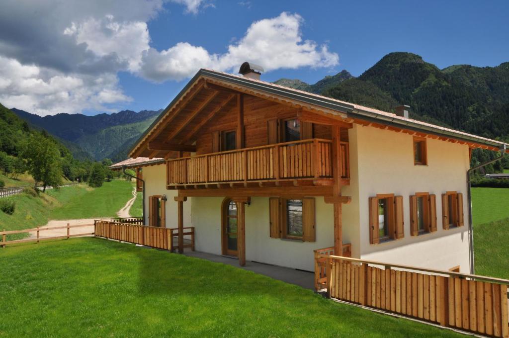 a house with a balcony on a green lawn at Garnì dal Mozat in Ledro