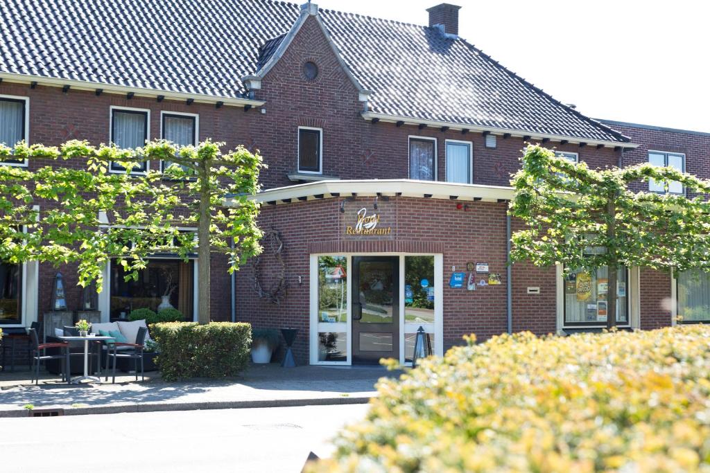 een bakstenen gebouw met een tafel en stoelen ervoor bij Hotel 't Zwaantje in Lichtenvoorde