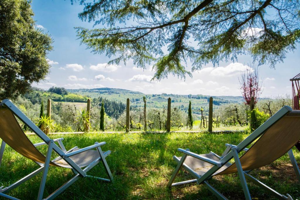 two chairs sitting in a field of grass with a view at Villa Bonsi in Montaione