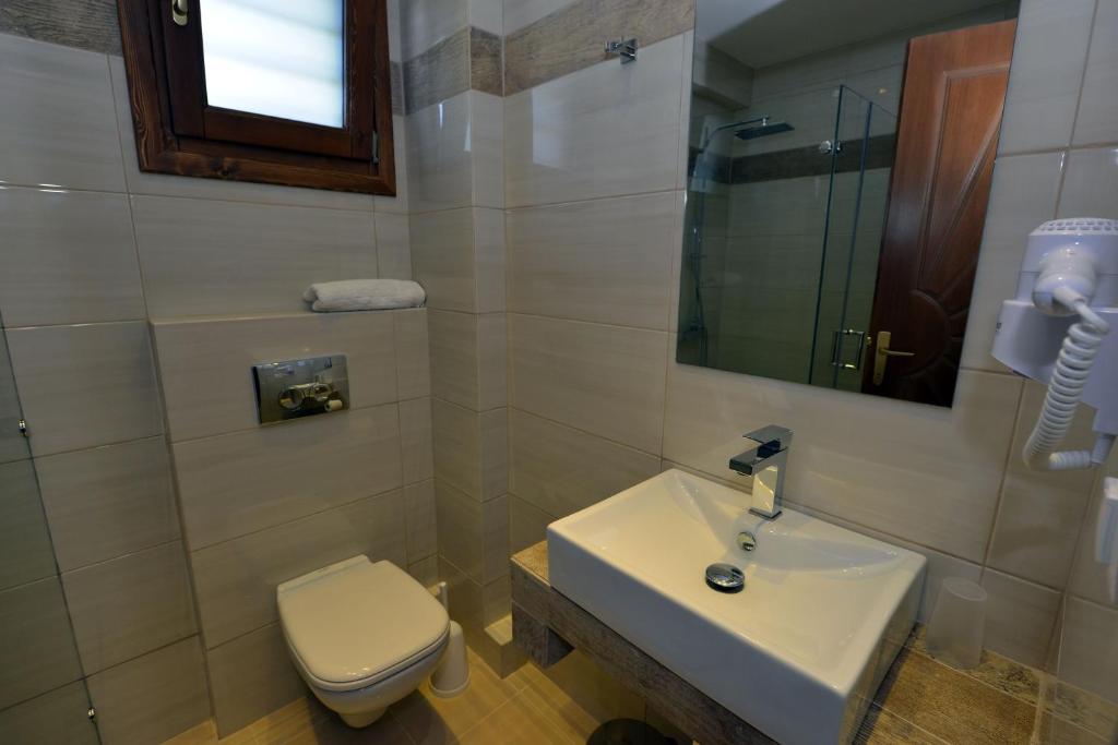 a bathroom with a white sink and a toilet at Haus Katerina in Vourvourou