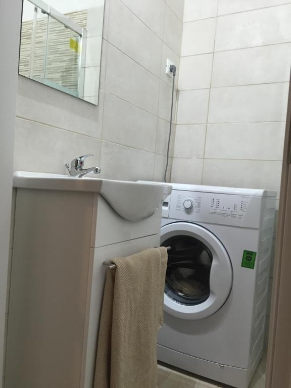 een badkamer met een wasmachine en een wastafel bij Monolocale nizza 27 in Turijn