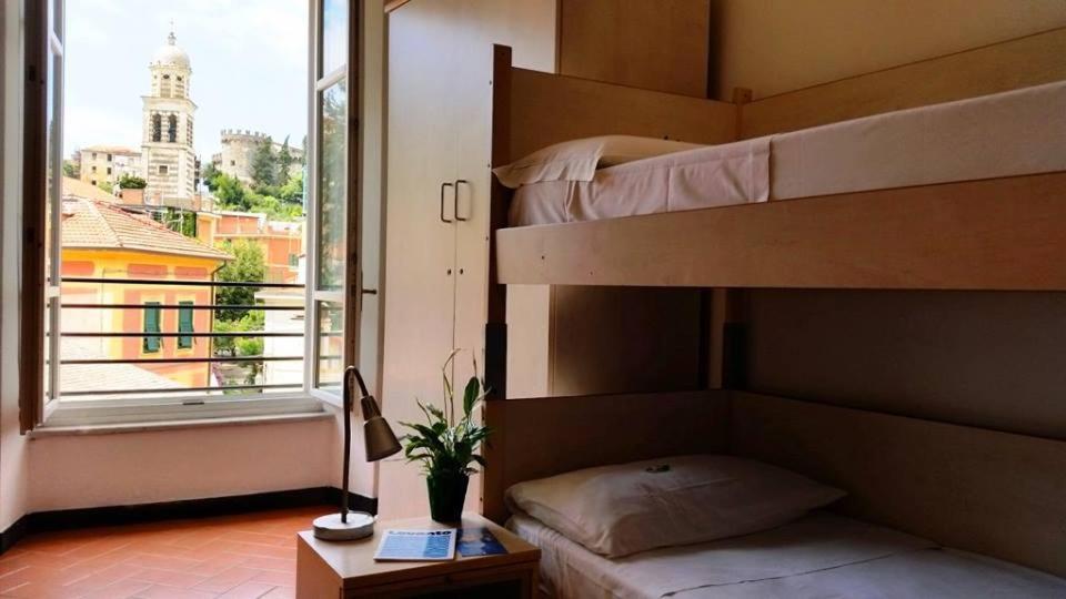 een slaapkamer met een stapelbed en uitzicht op de stad bij Ospitalia del Mare Hostel in Levanto