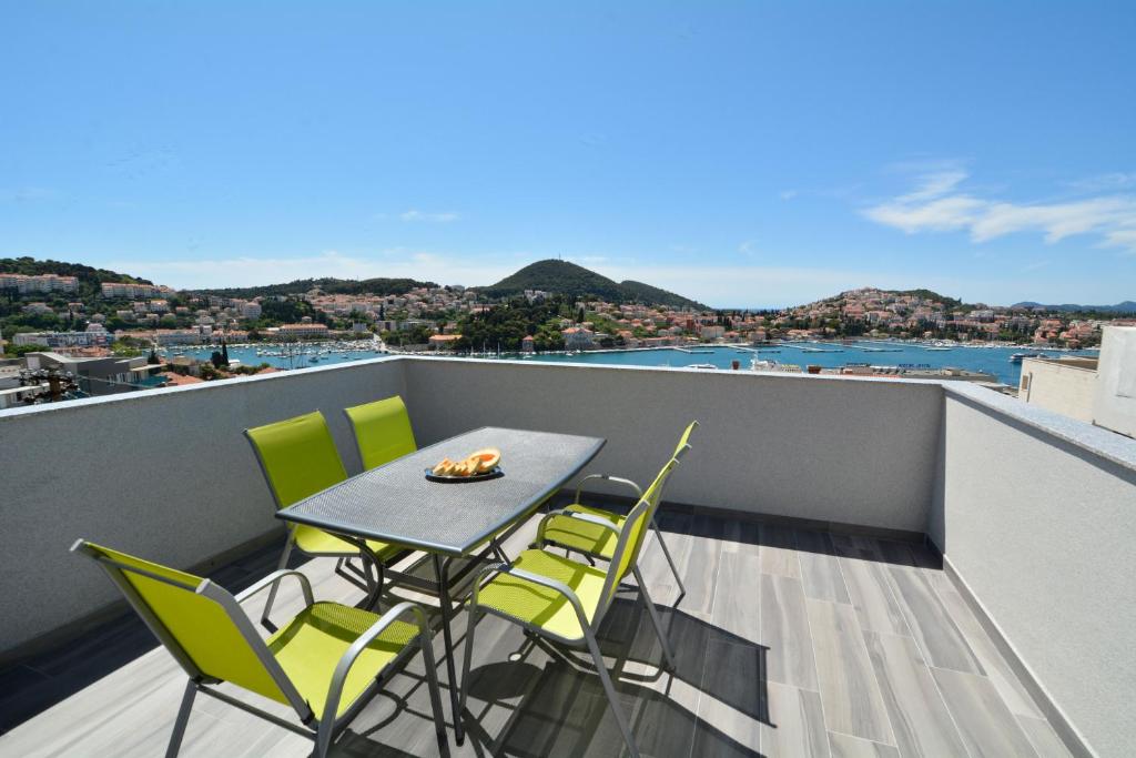 a balcony with a table and chairs on a roof at Villa Rosa in Dubrovnik