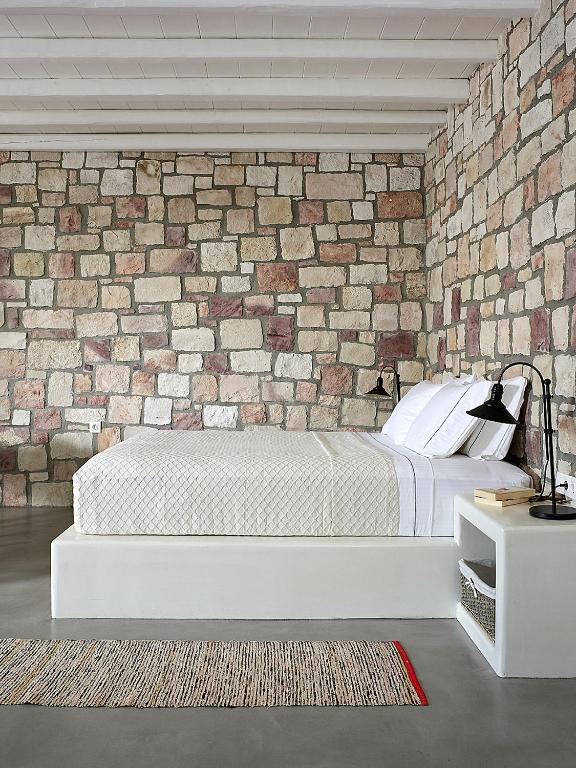 a bedroom with a brick wall and a bed at Studio Vipera in Triovasálos