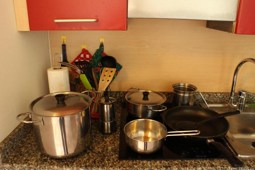 a kitchen counter with pots and pans on a stove at Chalet Presanella in Temù