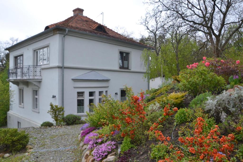 una casa blanca con flores delante en Villarada en Łagów