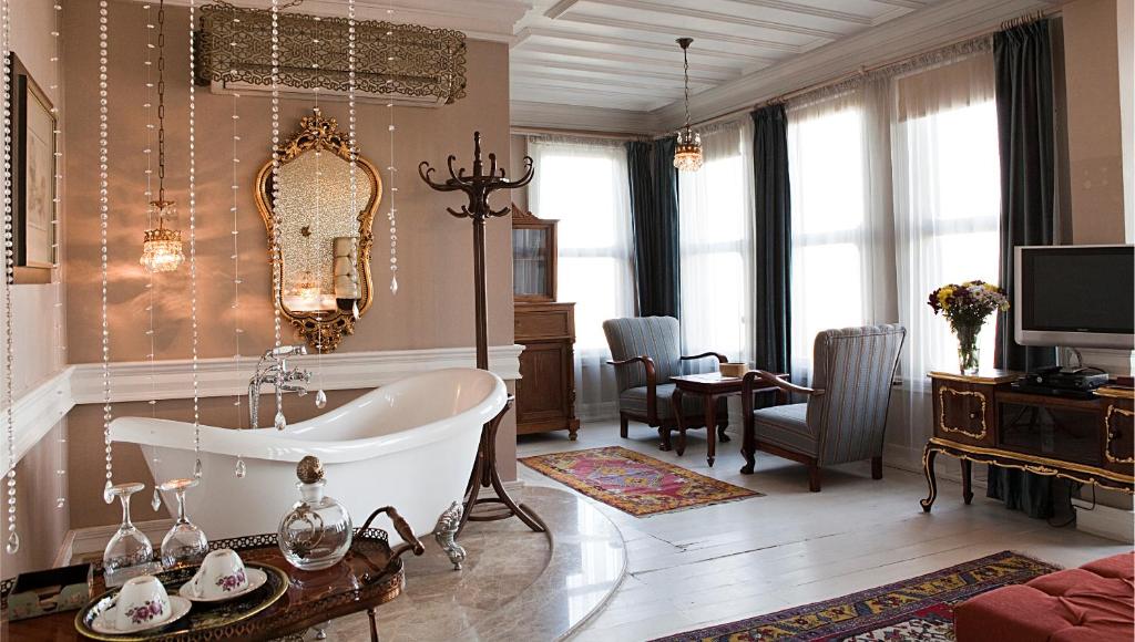 a bathroom with a tub and a living room at Kitapevi Hotel in Bursa