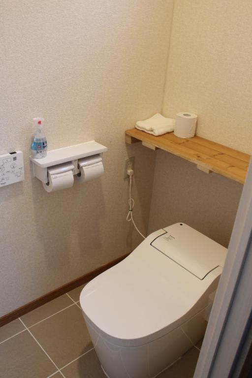 a bathroom with a white toilet in a room at Guest House Miyakojima in Miyako-jima