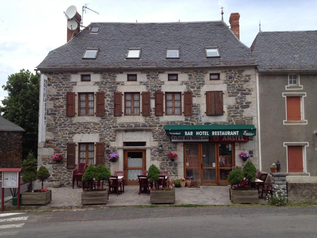 an old stone building with tables and chairs in front of it at Le Relais des Sites in Faverolles
